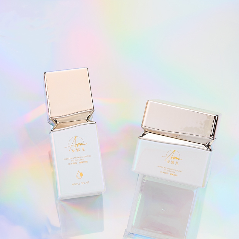 Neliönmuotoinen lasivoidepurkki irisoivalla vaikutuksella kasvo- ja silmänympärysvoiteeseen Neliönmuotoinen lasivoidepurkki irisoivalla vaikutuksella kasvo- ja silmänympärysvoiteeseen