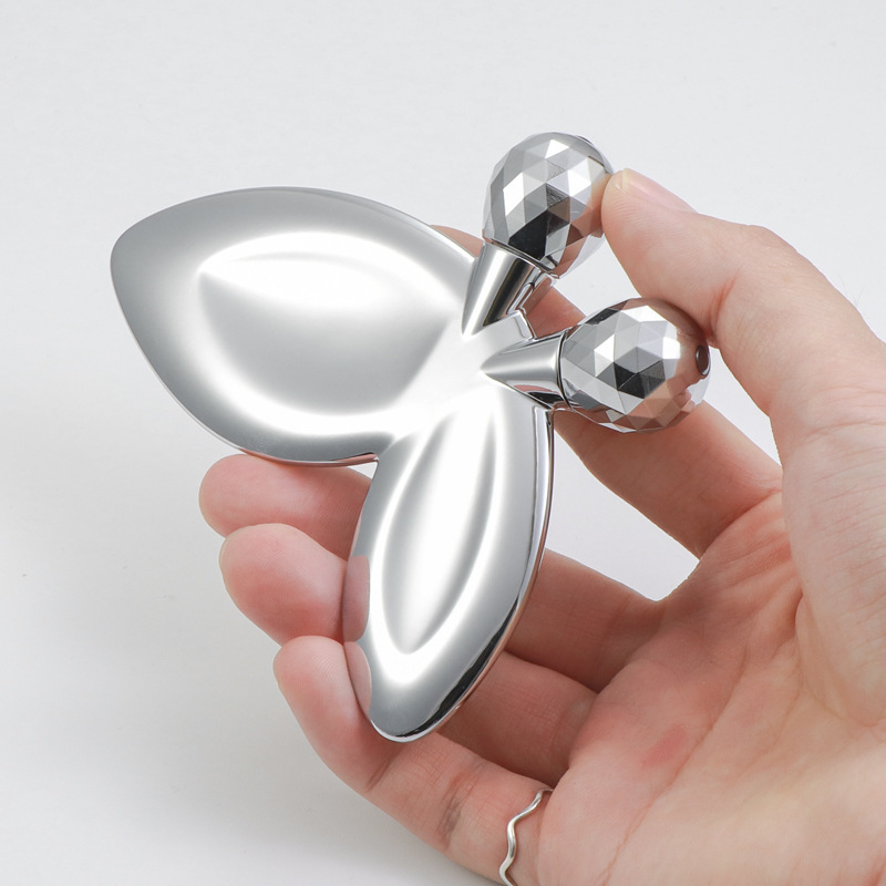 Sinkkiseoksesta valmistettu perhosen muotoinen kasvohierontarulla Sinkkiseoksesta valmistettu perhosen muotoinen kasvohierontarulla